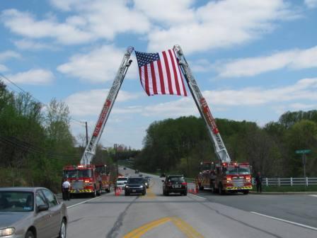 Truck 725 & Truck 712 cross aerials with the Flag of the United States of America to receive the funeral procession for the Line of Duty Death of MCPD Sergeant Hector Ayala.
<br><br>
End of Watch - 4 April 2010